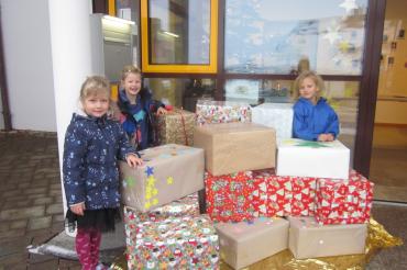 Auf dem Bild präsentieren Johanna, Marie und Frida stolz die Pakete, die kurz darauf vom großen Johanniter-Fahrzeug, sogar mit Blaulicht, abgeholt wurden.