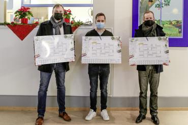 Daniel Petrasch (l.) und Götz Stamm (r.) von der SIGEL GmbH überreichen Jörg Speer (M.) die Schreibunterlagen. Der Leiter der Kindertagesstätte St. Martin in Mertingen freute sich sehr über das Geschenk.