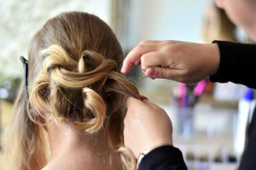 Friseur frisiert Frau