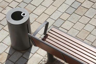 Straßenbank und Mülleimer auf Pflastersteinen