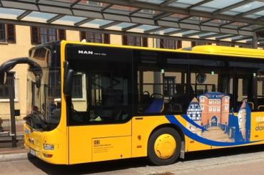 Gelber Bus steht an Haltestelle