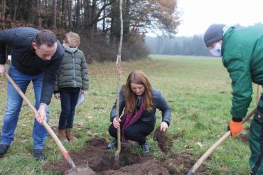 Das Bild zeigt Anna-Maria Böswald beim Pflanzen eines Baumes.