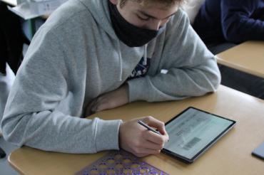 Das Bild zeigt einen Jungen am Tablet.