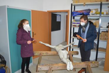 Das Bild zeigt Bürgermeister Thomas Heydecker und Michelle Grieb, Mitarbeiterin des Bauamts,  wie sie die Christus-Figur mit den Zeitkapseln befüllen.