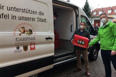 AOK-Direktor Michael Meyer übergibt die Nudel-Spende an Norbert Jakesch und Hugo Gruber.