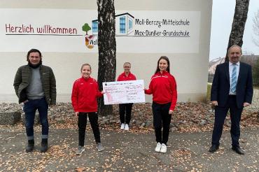 Fünf Personen mit Spendenscheck vor Schule Wallerstein