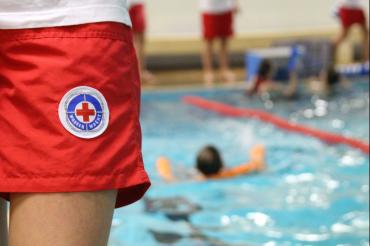 Träger einer Wasserwacht-Hose vor Schwimmbecken