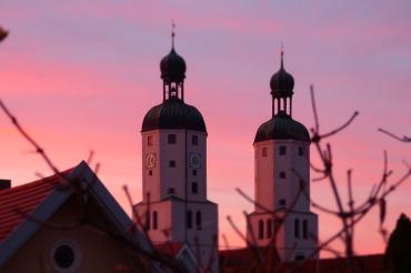Das Bild zeigt die Wemdinger Stadtpfarrkirche bei Sonnenuntergang. 