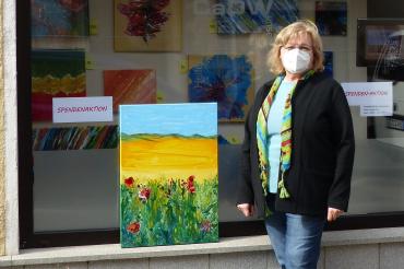 Das Bild zeigt Gudrun Handschuh mit einem ihrer Bilder. 