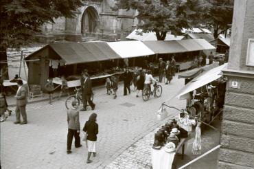 Das Bild zeigt Marktstände zur Nördlinger Mess‘ im Jahr 1949 vor der St. Georgs-Kirche.