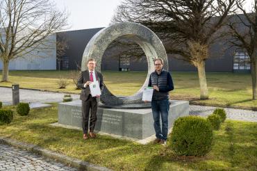 Das Bild zeigt Landrat Stefan Rößle und Prokurist Friedrich Gerlinger bei der Urkundenübergabe. 