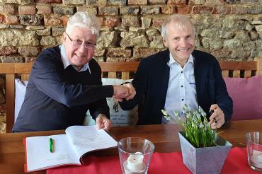 Das Bild zeigt den Hama Geschäftsführer Christoph Thomas bei der Vertragsunterzeichnung mit Bruno Messingschläger. 