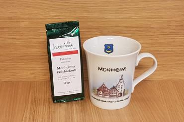 Das Bild zeigt eine Tasse mit dem Motiv von Monheim - daneben steht eine Tee-Mischung.