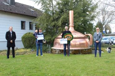Das Bild zeigt die Mitarbeiter der Brauerei Oettinger bei der Scheckübergabe