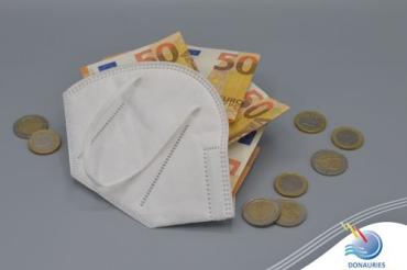 Das Bild zeigt eine FFP2-Maske mit Geld drinnen