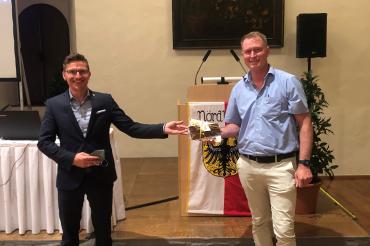 Oberbürgermeister David Wittner dankt Stadtbaumeister Hans-Georg Sigel mit einem besonderen Geschenk: Ein „Nördlinger Stadtmauer Schreiber“ aus Stadtmauerholz soll ihn an seine Zeit in Nördlingen erinnern.