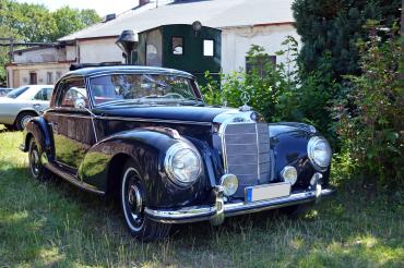 Auf dem Bild ist ein blauer Oldtimer zu sehen. 