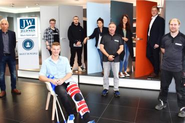 Das Bild zeigt Karl-Heinz Hederer (Head of Compensation & Benefits), Marina Dirr, Marius Beck (sitzend), Maximilian Eckl, Karin Dorn (Ausbilderin), Thomas Lutze (stellvertretender BR-Vorsitzender), Esther Huggenberger, Ingo Heger (Director Operations Risk/CI) und Daniel Rehle (Ausbilder).