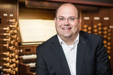 Mann im Anzug vor Kirchenorgel