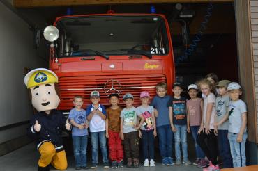 Kinder mit Feuerwehrmann Sam vor Feuerwehrauto