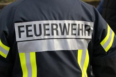 Das Bild zeigt die Aufschrift "Feuerwehr" auf einer Weste. 