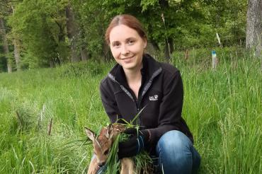 Das Bild zeigt Carolin König mit einem Rehkitz