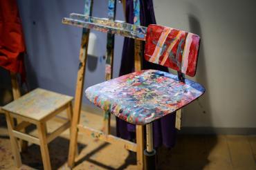 Das Bild zeigt einen bemalten Holzstuhl. 