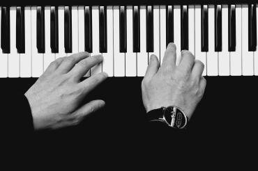 Schwarz-weiß-Bild von Händen an einer Klaviatur