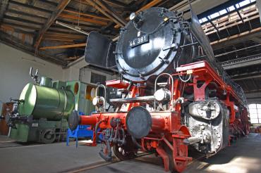 Schwarze und grüne Dampflok in einer Halle