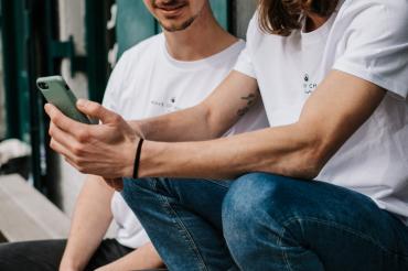 Das Bild zeigt zwei Männer mit Smartphone. 