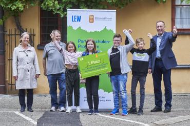 Im Beisein von Rektorin Birgit Obermair hat LEW-Kommunalbetreuer Peter Kraus (rechts) den Preis offiziell an die Siegerklasse und Dieter Scholz, Lehrer und Leiter der Projektgruppe (2.v.l.), übergeben.