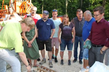 Elf Personen stehen vor Bohrgerät