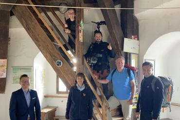 Sechs Personen auf und neben einer Holztreppe