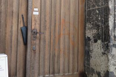 Tür einer Kirche, darauf ein "A" in einem Kreis gemalt