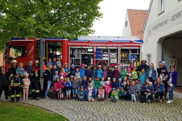 Gruppenbild der Kindergartenkinder und Feuerwehrleute. 