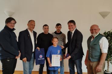 Das Bild zeigt: Johanna (in der Bildmitte mit Urkunde) mit (von links) Benjamin Schäfer (Technischer Leiter Kreiswasserwacht Nordschwaben), Michael Haller (Vorsitzender der Wasserwacht Ortsgruppe Asbach-Bäumenheim), die beiden Geretteten Ioan-Madalin Nistor und Ioan-Iosif Boca, Zweiter Bürgermeister Andreas Mayer und Erhard Schiele (Geschäftsführer ESG Kräuter GmbH).