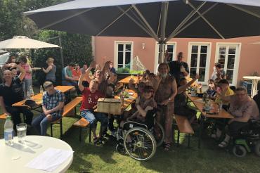 Das Bild zeigt die Bewohnerinnen und Bewohner der Bergerstraße und in der Mitte stehend Judith Meyer, im Hintergrund stehend Fachbereichsleitung Uwe Dolzer.