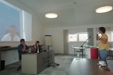 Leinwand mit Klaus Holetschek, davor Mann und Frau an einem Podium, rechts Frau an Mikrofonständer