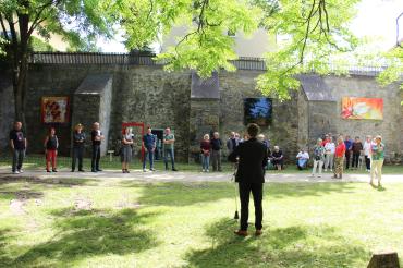 David Wittner, Rücken zur Kamera, hält Rede vor Personen vor Nördlinger Stadtmauer