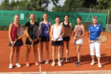 Sieben Tennisspielerinnen mit Rackets auf Tennisplatz