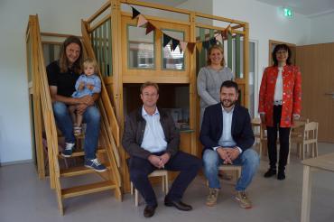 Fünf Erwachsene und ein Kind in Kindergartenraum mit Spiellandschaft