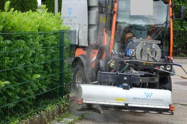 Straßenreinigungsmaschine bekämpft Unkraut mit Heißwasser