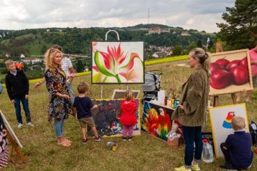 Auf dem Bild zu sehen Malgosia Neher und Besucher an der Staffelei am Leiterberg.