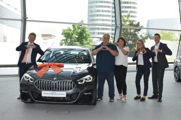 Auf dem Bild zu sehen Familie Volt beim Abholen des Autos.