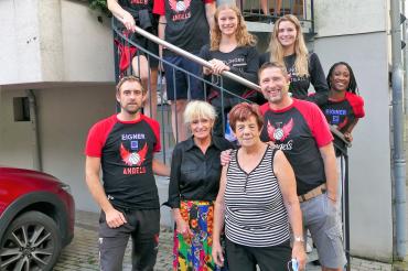 Basketballerinnen mit Funktionären und Wirtin auf Wendeltreppe