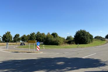 Straßenkreuzung mit Begrünung und Verkehrsschildern