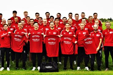 Auf dem Bild sieht man die Fußballmannschaft mit ihren neuen Trikots.