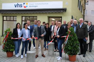 Gruppenbild mit 17 Personen bei Banddurchschneidung vor Geschäftsstelle der Rieser Volkshochschule