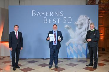 Die Auszeichnung „Bayerns Best 50“ nahm Geschäftsführer Gunnar Bregler (mitte) für die UNSINN Fahrzeugtechnik von Juror Prof. Dr. Thomas Edenhofer (links) sowie von Bayerns Wirtschaftsstaatssekretär Roland Weigert entgegen.