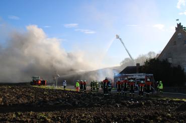 Feuerwehrkräfte beim Löschen einer brennenden Halle